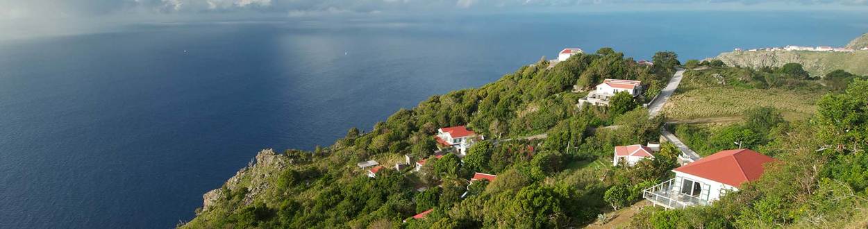 Saba spectaculair uitzicht over de oceaan met huizen tegen de groene heuvels